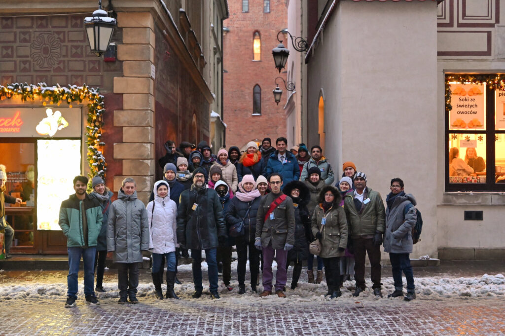 Group of about 30 people standing at the steps of the Warsaw's Old Town 